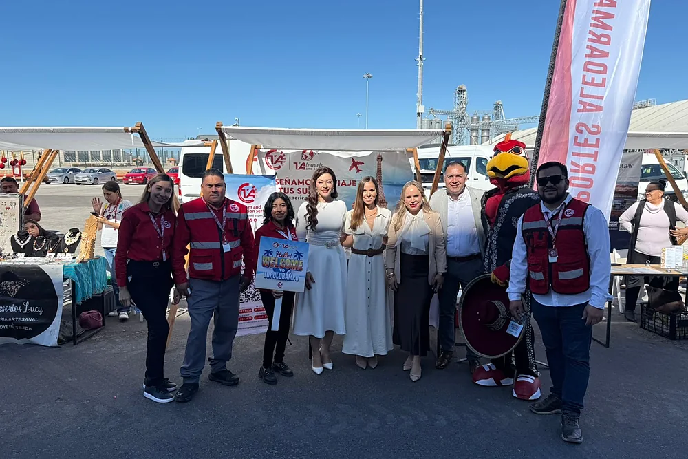El equipo de la agencia y la mascota en el módulo de bienvenida del puerto
