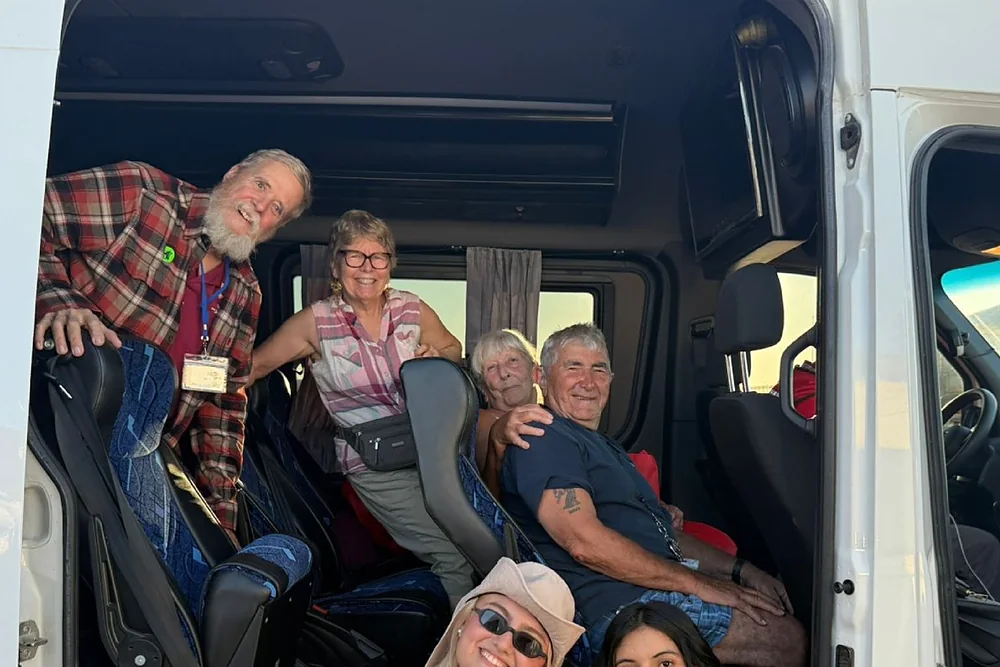 Pasajeros sonriendo dentro de una van de la agencia antes de salir al tour